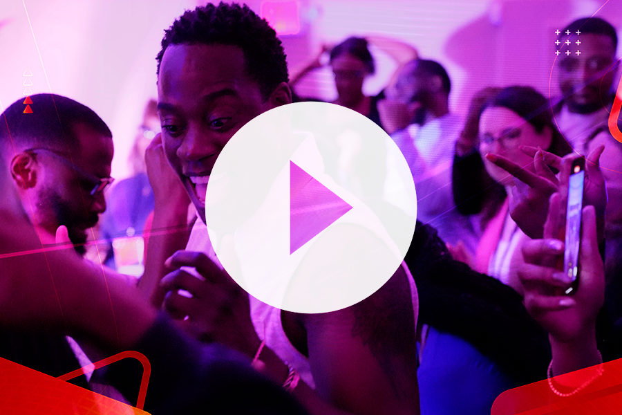 video thumbnail Image of people dancing at a party with a play button overlay on the image. clicking the image will open the sizzle reel video